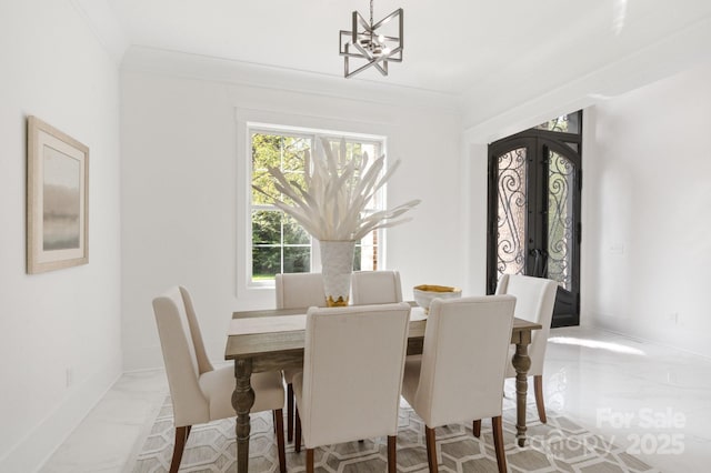 dining space featuring a notable chandelier, crown molding, and french doors