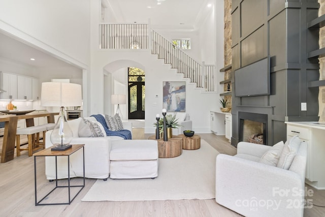 living room with a towering ceiling and light wood-type flooring