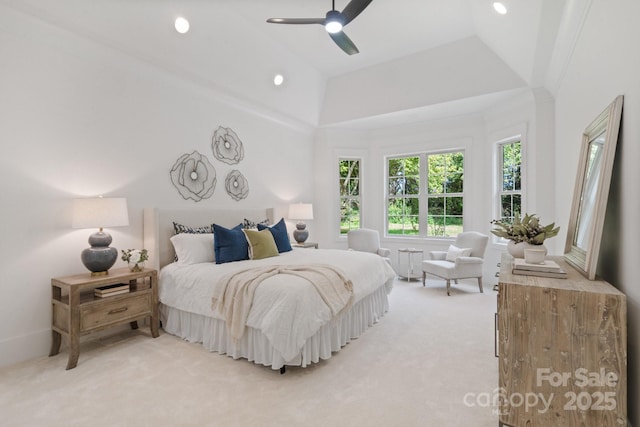 bedroom featuring a towering ceiling, light colored carpet, and ceiling fan