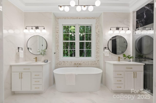 bathroom featuring vanity, ornamental molding, and a washtub