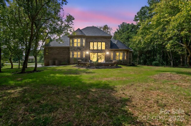 back house at dusk with a yard