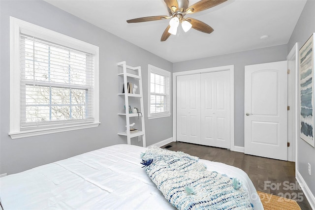 bedroom featuring ceiling fan, dark hardwood / wood-style flooring, and a closet