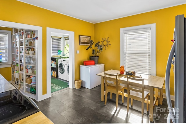 dining area featuring independent washer and dryer and a healthy amount of sunlight