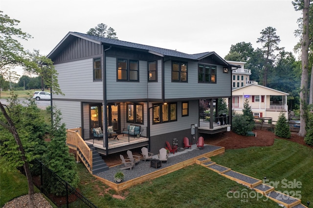 rear view of house featuring a yard, a patio, and an outdoor fire pit