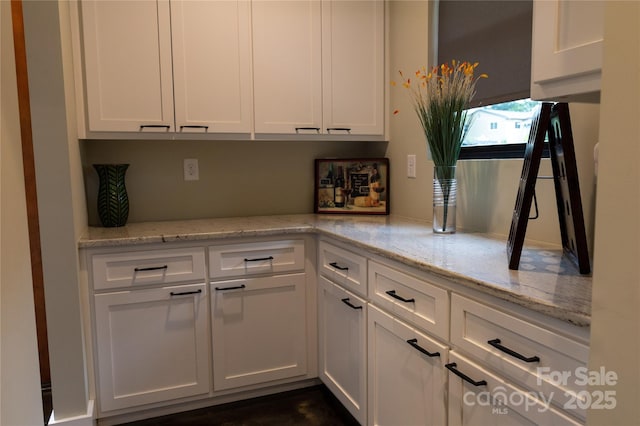 kitchen featuring white cabinetry and light stone counters