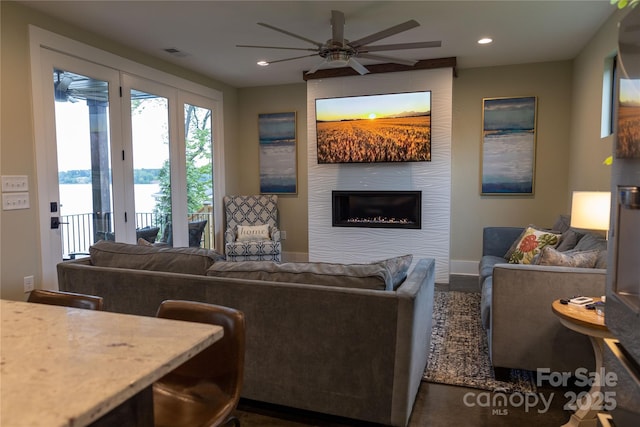 living room featuring ceiling fan and a fireplace