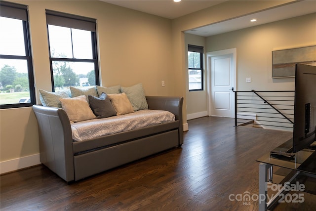 living room with plenty of natural light and dark hardwood / wood-style flooring