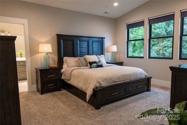 bedroom with vaulted ceiling and light carpet