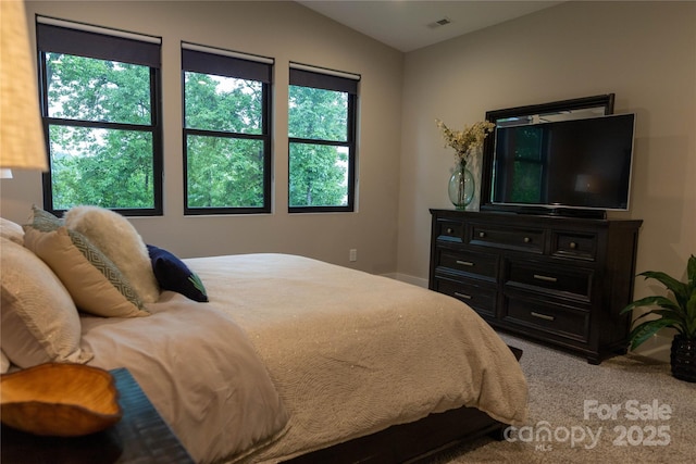 bedroom with lofted ceiling and light carpet