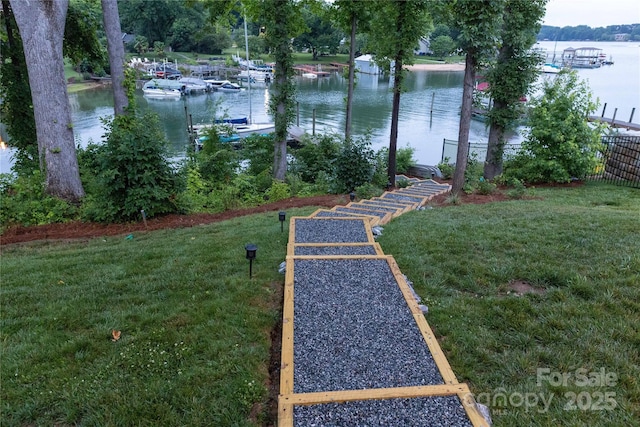 view of yard featuring a water view and a dock