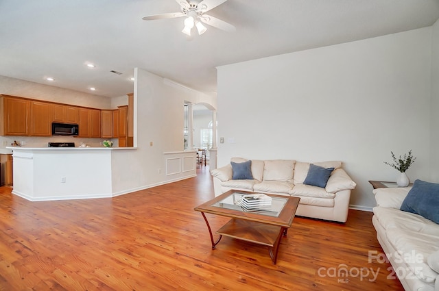 living room featuring ceiling fan and light hardwood / wood-style flooring