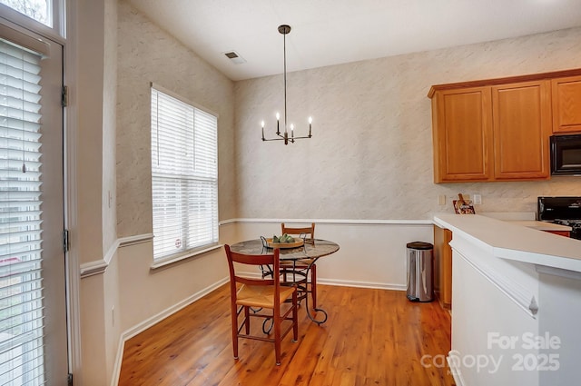 dining area featuring a notable chandelier and light hardwood / wood-style flooring