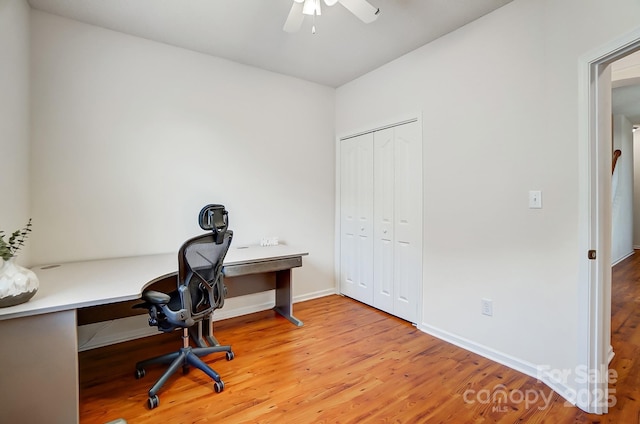 office with light hardwood / wood-style flooring and ceiling fan