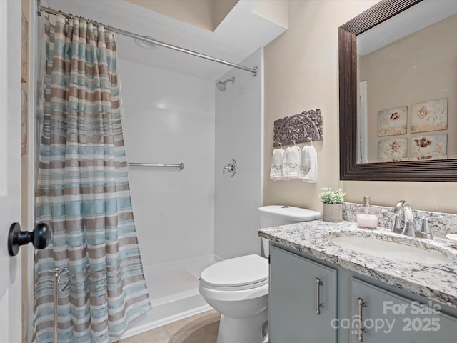 bathroom featuring vanity, tile patterned flooring, toilet, and walk in shower