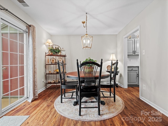 dining room with hardwood / wood-style floors and a notable chandelier