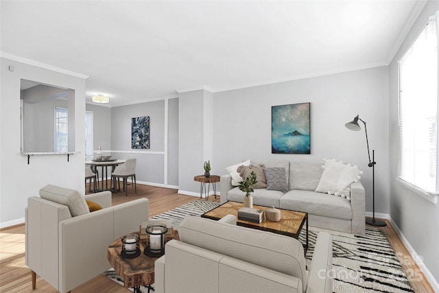 living room with crown molding, a wealth of natural light, and light wood-type flooring