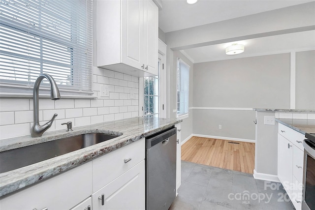 kitchen with white cabinetry, sink, decorative backsplash, stainless steel appliances, and light stone countertops