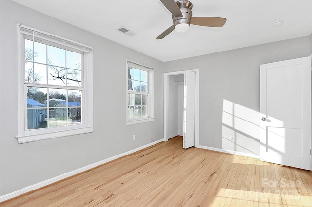 unfurnished bedroom featuring ceiling fan, light hardwood / wood-style floors, and multiple windows