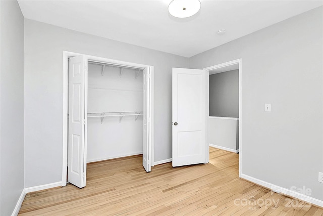 unfurnished bedroom featuring light wood-type flooring and a closet