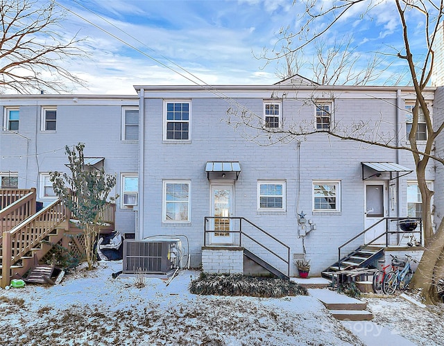 snow covered property featuring central air condition unit