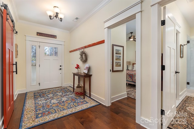 entryway with crown molding, a barn door, dark hardwood / wood-style flooring, and ceiling fan with notable chandelier