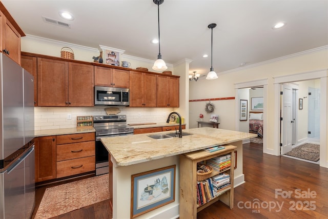 kitchen with sink, light stone counters, decorative light fixtures, a center island with sink, and stainless steel appliances