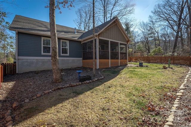 back of property featuring a sunroom and a lawn