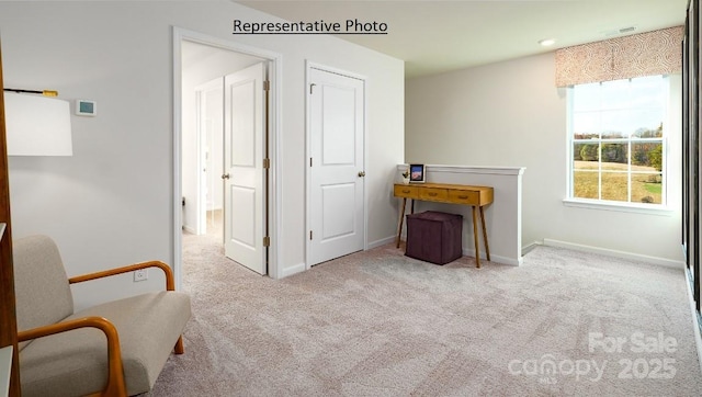 sitting room featuring light colored carpet