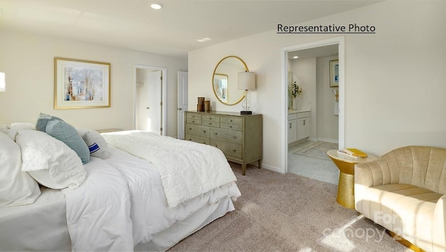 bedroom with light colored carpet and ensuite bathroom