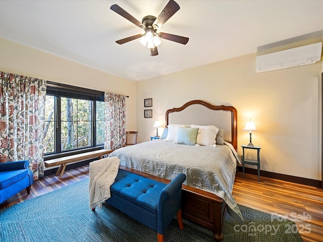 bedroom with wood-type flooring, a wall mounted AC, and ceiling fan