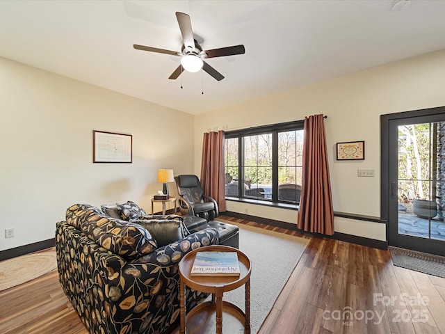 living room featuring ceiling fan, plenty of natural light, and wood-type flooring