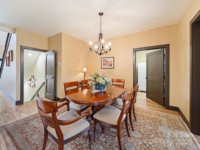 dining space featuring light hardwood / wood-style floors and a chandelier