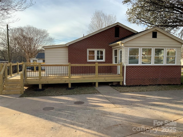 rear view of house featuring a deck and a sunroom