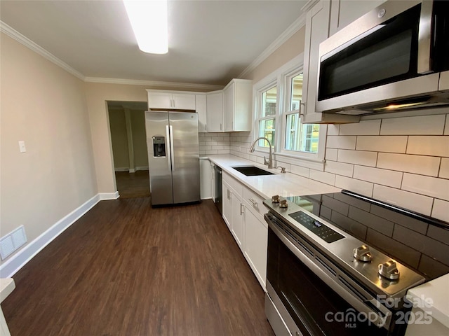 kitchen with sink, white cabinetry, stainless steel appliances, dark hardwood / wood-style floors, and decorative backsplash