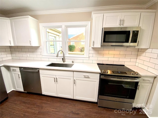 kitchen featuring sink, stainless steel appliances, tasteful backsplash, ornamental molding, and white cabinets