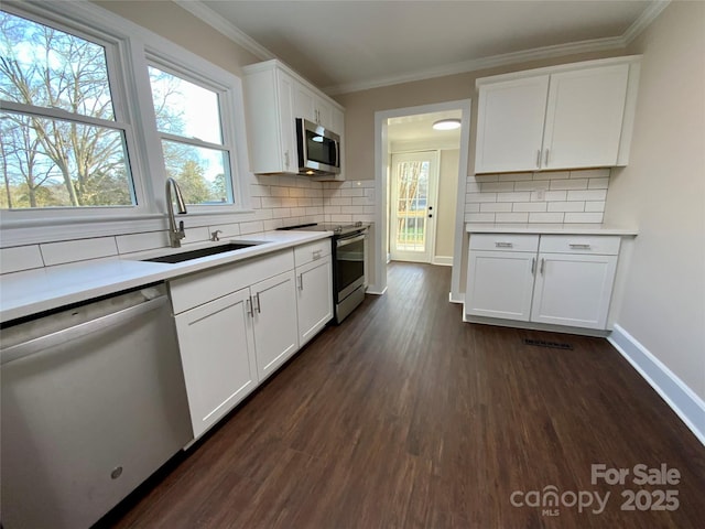 kitchen featuring dark hardwood / wood-style floors, white cabinetry, sink, backsplash, and stainless steel appliances