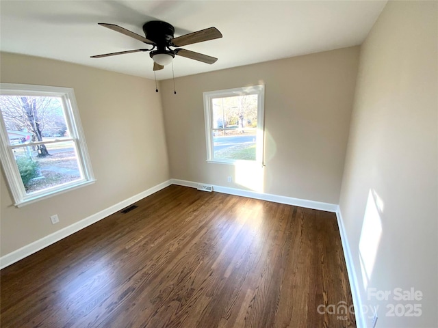 unfurnished room featuring ceiling fan, plenty of natural light, and dark hardwood / wood-style floors