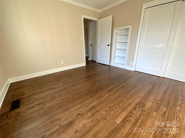 unfurnished bedroom featuring crown molding and dark hardwood / wood-style flooring