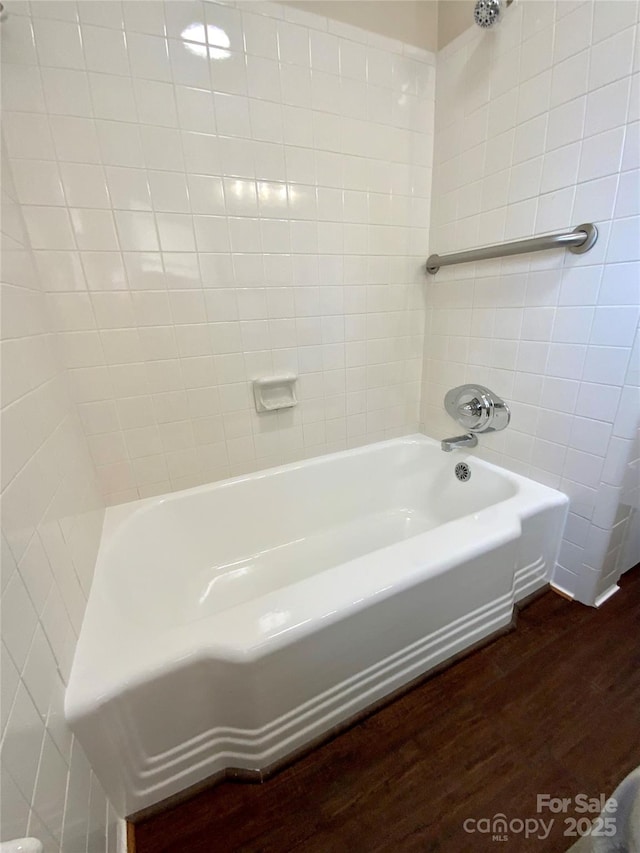 bathroom featuring tiled shower / bath combo and wood-type flooring