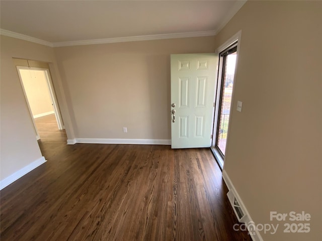 spare room featuring ornamental molding and dark hardwood / wood-style floors