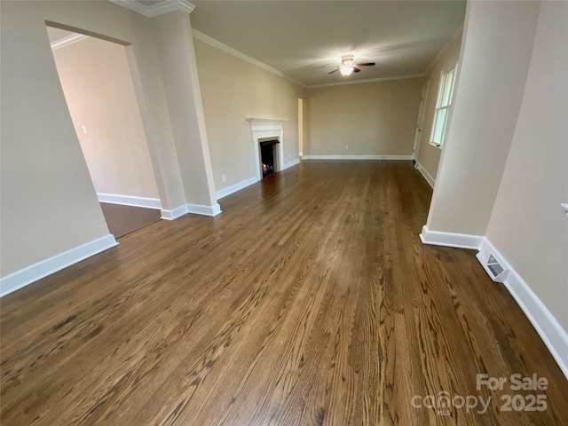 unfurnished living room featuring dark hardwood / wood-style flooring, ornamental molding, and ceiling fan