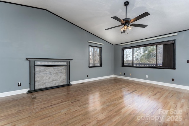 unfurnished living room featuring hardwood / wood-style flooring, vaulted ceiling, and ceiling fan