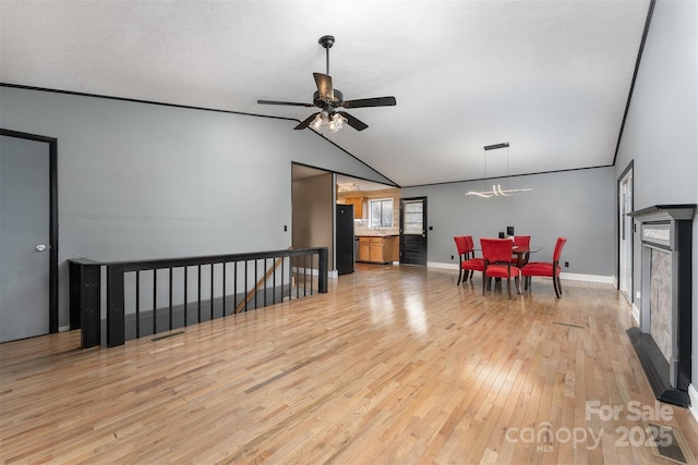 interior space with lofted ceiling, ceiling fan with notable chandelier, a textured ceiling, and light hardwood / wood-style flooring