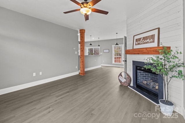 living room featuring ceiling fan, a large fireplace, and hardwood / wood-style floors