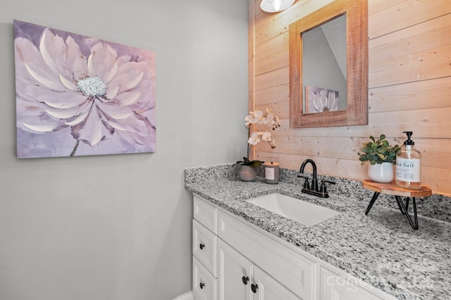 bathroom featuring vanity and wood walls