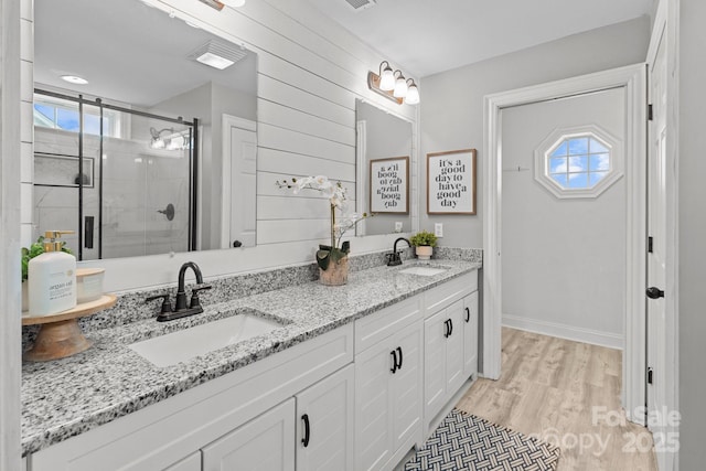 bathroom with hardwood / wood-style flooring, vanity, and a shower with shower door