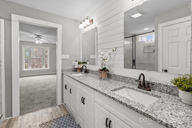 bathroom featuring vanity, hardwood / wood-style floors, ceiling fan, and walk in shower