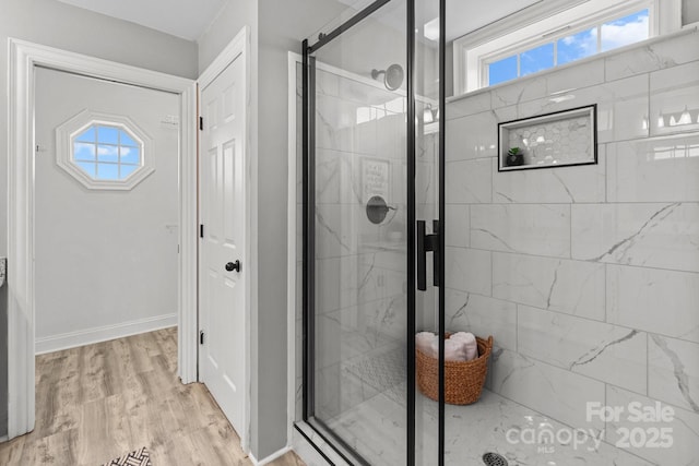 bathroom with an enclosed shower, hardwood / wood-style flooring, and a healthy amount of sunlight