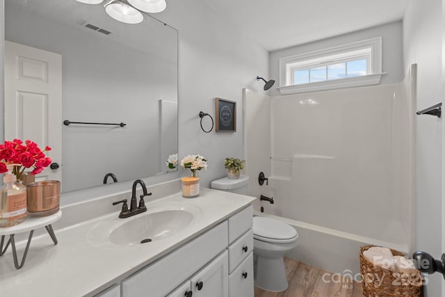 full bathroom with vanity, wood-type flooring, toilet, and washtub / shower combination