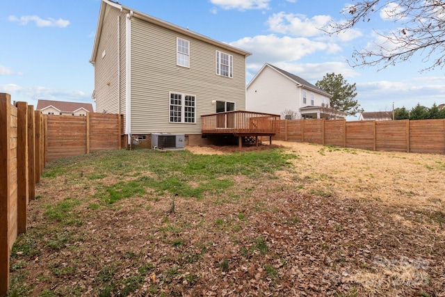 back of property featuring a wooden deck, central AC unit, and a lawn